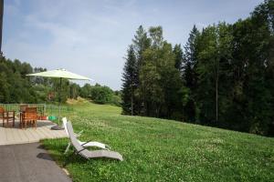 a lawn with a table and chairs and an umbrella at Ferienwohnung im bayerischen Wald in Tittling