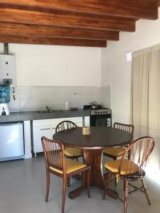 uma cozinha com uma mesa e cadeiras numa cozinha em Cabaña Molle by Lugar em El Manzano