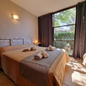 1 dormitorio con 1 cama con 2 toallas en Apartamentos Andrea en Villa General Belgrano