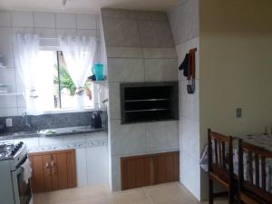 eine Küche mit einer Spüle, einem Herd und einem Fenster in der Unterkunft Casa em Torres Praia da Cal in Torres