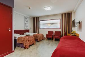 a hotel room with two beds and chairs and a window at Hotel Salora in Salo