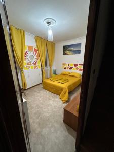 une chambre avec un lit jaune et des rideaux jaunes dans l'établissement Bed and breakfast chez l'habitant, à Marseille 19 autres photos