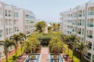 帕奈米林的住宿－Qavi - Flat em Resort Beira Mar Cotovelo #InMare109，享有棕榈树建筑庭院的空中景致