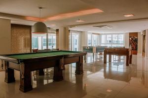 a room with a pool table and two tables at Qavi - Flat em Resort Beira Mar Cotovelo #InMare109 in Parnamirim
