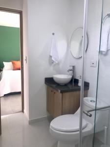 a white bathroom with a sink and a toilet at Torcaza Casa de Campo in Quimbaya