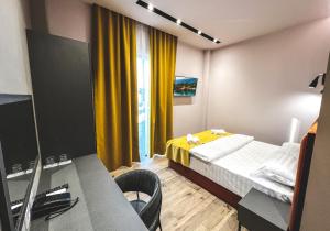 a room with a bed and a desk and a window at Nord Hotel Boutique in Shkodër
