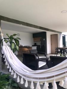a hammock in a living room with chairs and tables at Torcaza Casa de Campo in Quimbaya