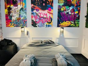 ドゥエーにあるCapsule Street Art - Sauna- Jacuzzi - Playstation 5 - Billard - Netflix - Home cinéma - Terrasseの壁に絵画が飾られた部屋のベッド1台