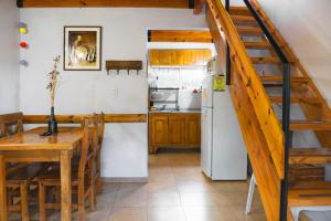 a kitchen and dining room with a table and a refrigerator at Cabañas Tranquera 8 in Chascomús