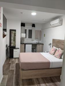 a bedroom with a large bed and a kitchen at hostal olozaga in Alicante