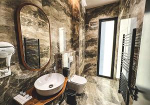 ein Badezimmer mit Waschbecken, Toilette und Spiegel in der Unterkunft Nord Hotel Boutique in Shkodra + 27 Fotos