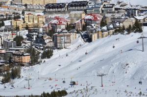 eine Gruppe von Personen, die auf einer schneebedeckten Piste Ski fahren in der Unterkunft Apartamentos Bulgaria in Sierra Nevada