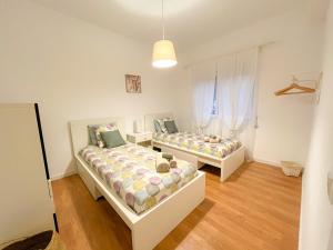 two beds in a room with wooden floors at BENAMAR HOUSE in Quarteira