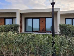 Casa con ventanas de cristal y luz de la calle en Sea Breeze Resort, White Villa, Nardaran en Bakú