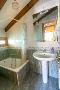 a bathroom with a sink and a bath tub and a sink at Apartamentos Rurales Villa-García in Corigos