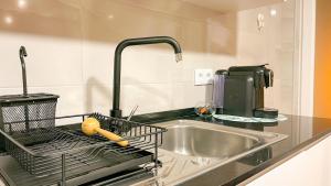 a kitchen sink with a dish drying rack next to it at BENAMAR HOUSE in Quarteira