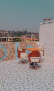 a patio with a table and chairs on a roof at Empire du Luxe in Yaoundé