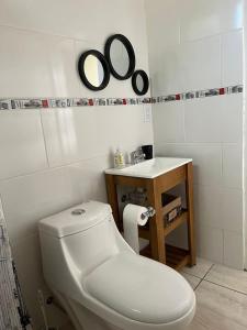 uma casa de banho com um WC branco e um lavatório. em Psalm23 em Tristán Suárez