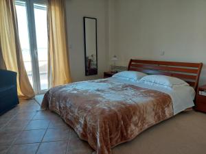 1 dormitorio con cama grande y ventana grande en Αξέχαστη διαμονή στο Πορτοχέλι en Porto Heli