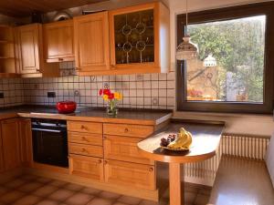 eine Küche mit Holzschränken und einem Tisch mit Bananen darauf in der Unterkunft Schwarzwald-Oase für bis zu 10 Personen in Dornstetten