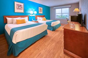a hotel room with two beds and a television at Sierra Suites By HP Hotels in San Luis Potosí