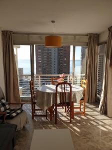 comedor con mesa y sillas y balcón en Apartment caballos levante beach en Benidorm