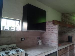 uma cozinha com fogão e uma televisão na parede em ESPACIO MINGA, casa quinta en la ciudad, hasta 8 personas em Corrientes