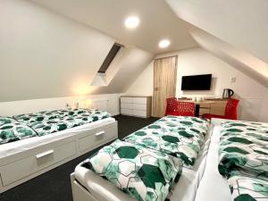 two beds in a room with a desk and a tv at Penzión Pavčina Lehota in Pavčina Lehota +123 photos