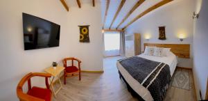 a bedroom with a bed and a tv and a table at Apart Hotel MiCasa in Futrono