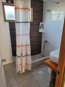 a bathroom with a shower curtain and a sink at Parcela Lago Rapel 
