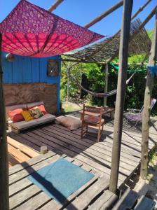 1 cama y 1 silla en una terraza de madera en Mirando el Mar, en Barra de Valizas