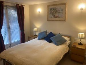 a bedroom with a large bed with blue pillows at 1 Coach House Mews - Matlock Bath in Matlock Bank