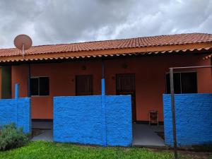 una casa con paredes pintadas de azul delante de ella en suítes Bomfass, en Alto Paraíso de Goiás