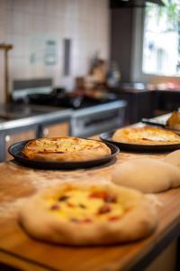 drei Pizzen auf einer Theke in einer Küche in der Unterkunft Hostel Like Quijote in San Carlos de Bariloche