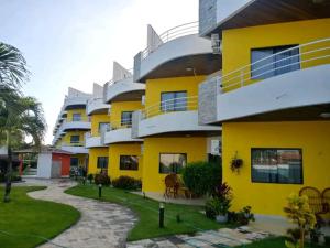 a building with yellow and white at Condominio com vista para o mar in Nísia Floresta