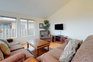 a living room with a couch and a tv at Newport's Cypress Oceanview Home in Newport
