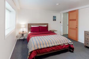 - une chambre avec un grand lit et des oreillers rouges dans l'établissement Newport's Cypress Oceanview Home, à Newport