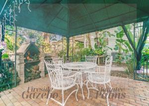 a table and chairs in a patio with a fireplace at Manatee Palms in Bradenton