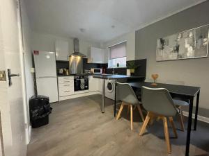 a kitchen with a dining room table and chairs at Dunbeth House in Coatbridge
