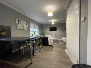 a dining room and living room with a table and chairs at Dunbeth House in Coatbridge