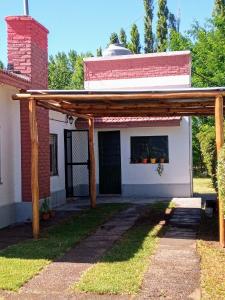 a wooden pergola in front of a house at Casa mora! in Neuquén +3 photos