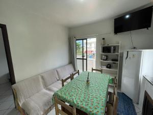 een woonkamer met een tafel en een bank bij Apê Brisa do Mar: relaxe a uma quadra da praia in Itapoa