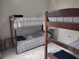 Двухъярусная кровать или двухъярусные кровати в номере Apê Brisa do Mar: relaxe a uma quadra da praia