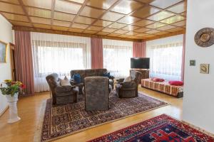 ein Wohnzimmer mit Stühlen, einem Sofa und einem TV in der Unterkunft Ferienhaus Annerose in Wendisch Rietz