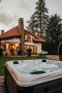una bañera de hidromasaje frente a una casa en Zarabie Residence, en Myślenice