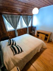 a bedroom with a large bed with a window at Hostel Like Quijote in San Carlos de Bariloche