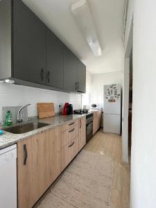 uma cozinha com armários de madeira e um frigorífico branco em Apartamento Hifrensa em L'Hospitalet de l'Infant