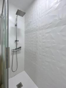 een witte badkamer met een douche en een glazen deur bij Apartamento Hifrensa in Hospitalet de l'Infant