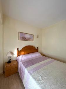 um quarto com uma cama e um candeeiro numa mesa de cabeceira em Apartamento Hifrensa em L'Hospitalet de l'Infant