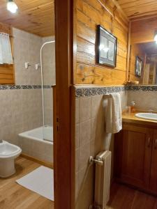 y baño con aseo, lavabo y bañera. en La Soñada casa de montaña en San Martín de los Andes
